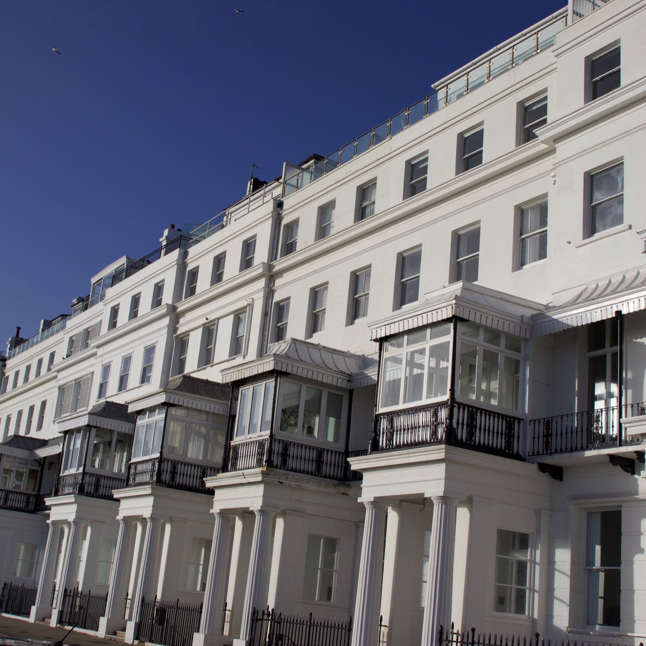 White building with multiple balconies and large windows in central Brighton