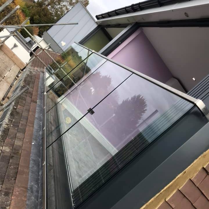 Modern building with large glass windows and a balcony railing.