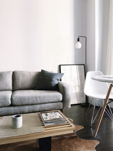 Modern living room featuring a grey sofa, a wooden coffee table, and a white dining chair.