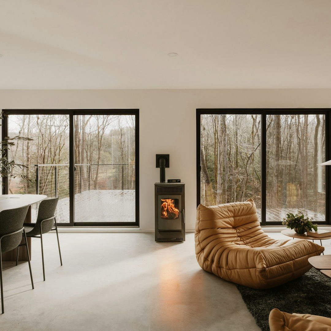 Modern kitchen and living area with large skylights, white cabinets, and a red chair. In  Brighton,Hove, Sussex area. 