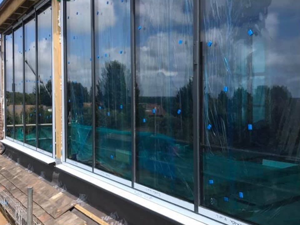 Construction site with a large mound of earth and a partially demolished house.